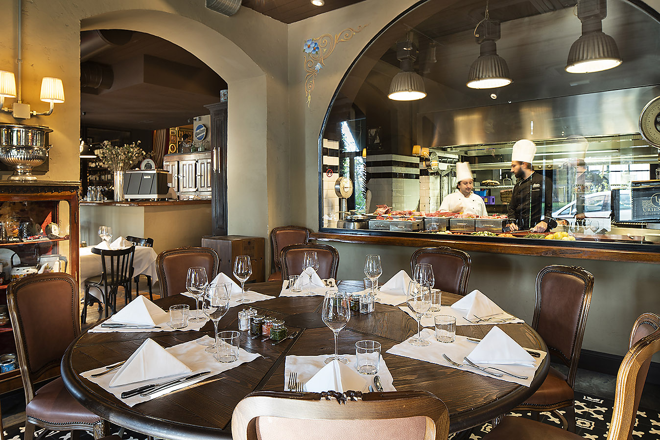 Scorcio del Porteno ASrena con tavlo rotondo apparecchiato e cucina a vista sullo sfondo